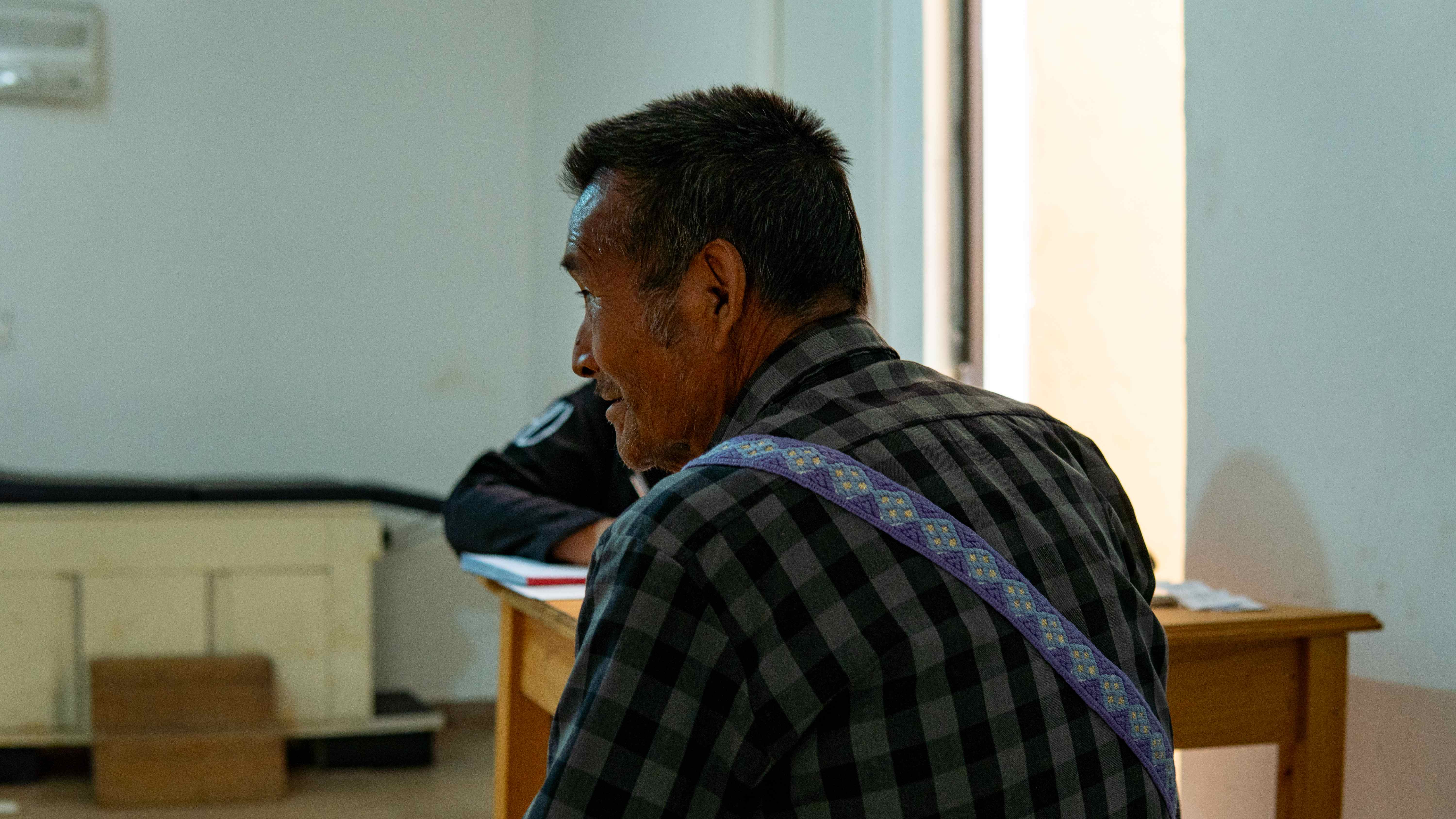 Hombre mayor de la comunidad esperando atención en la clínica.
