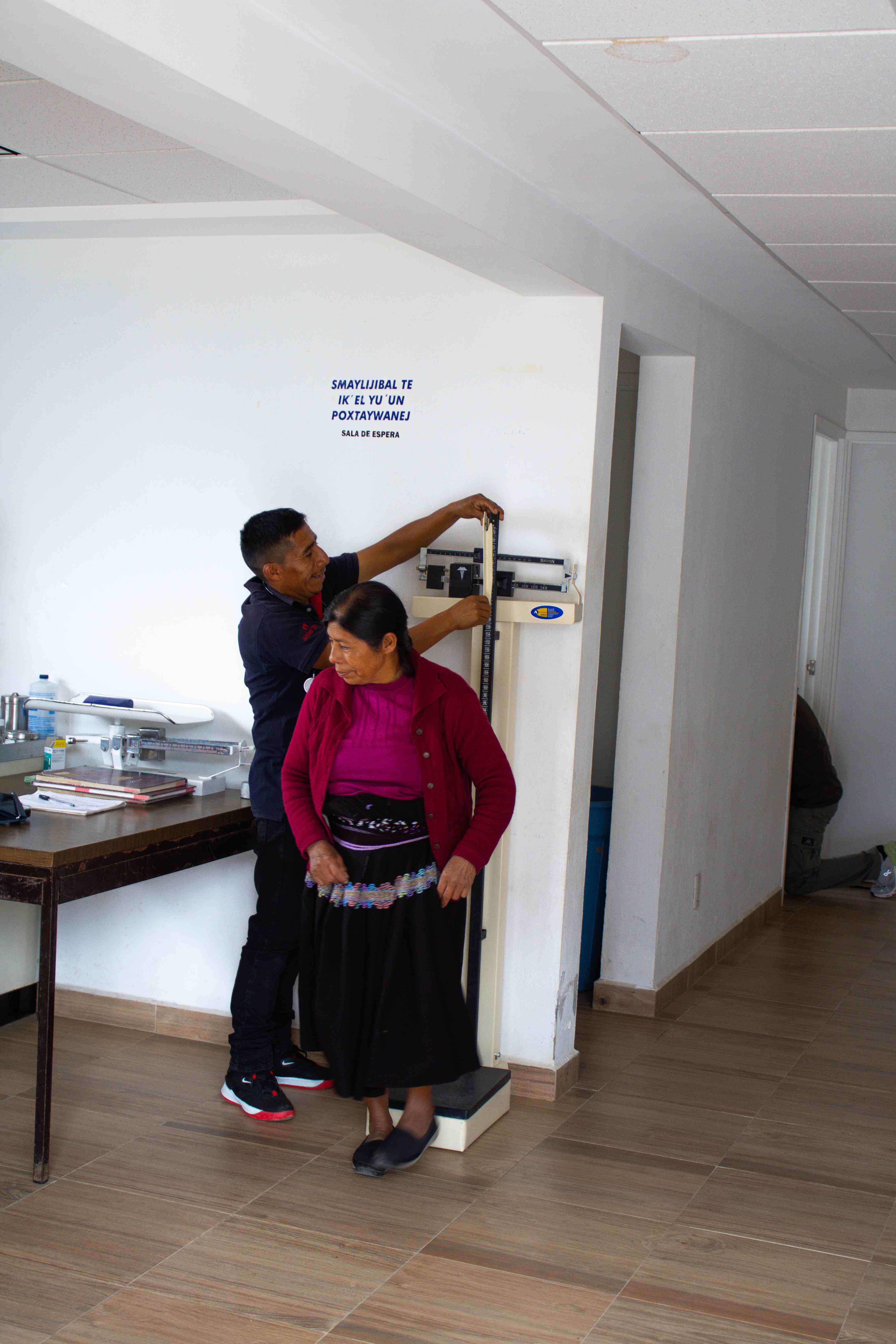 Personal médico midiendo la altura de una paciente.