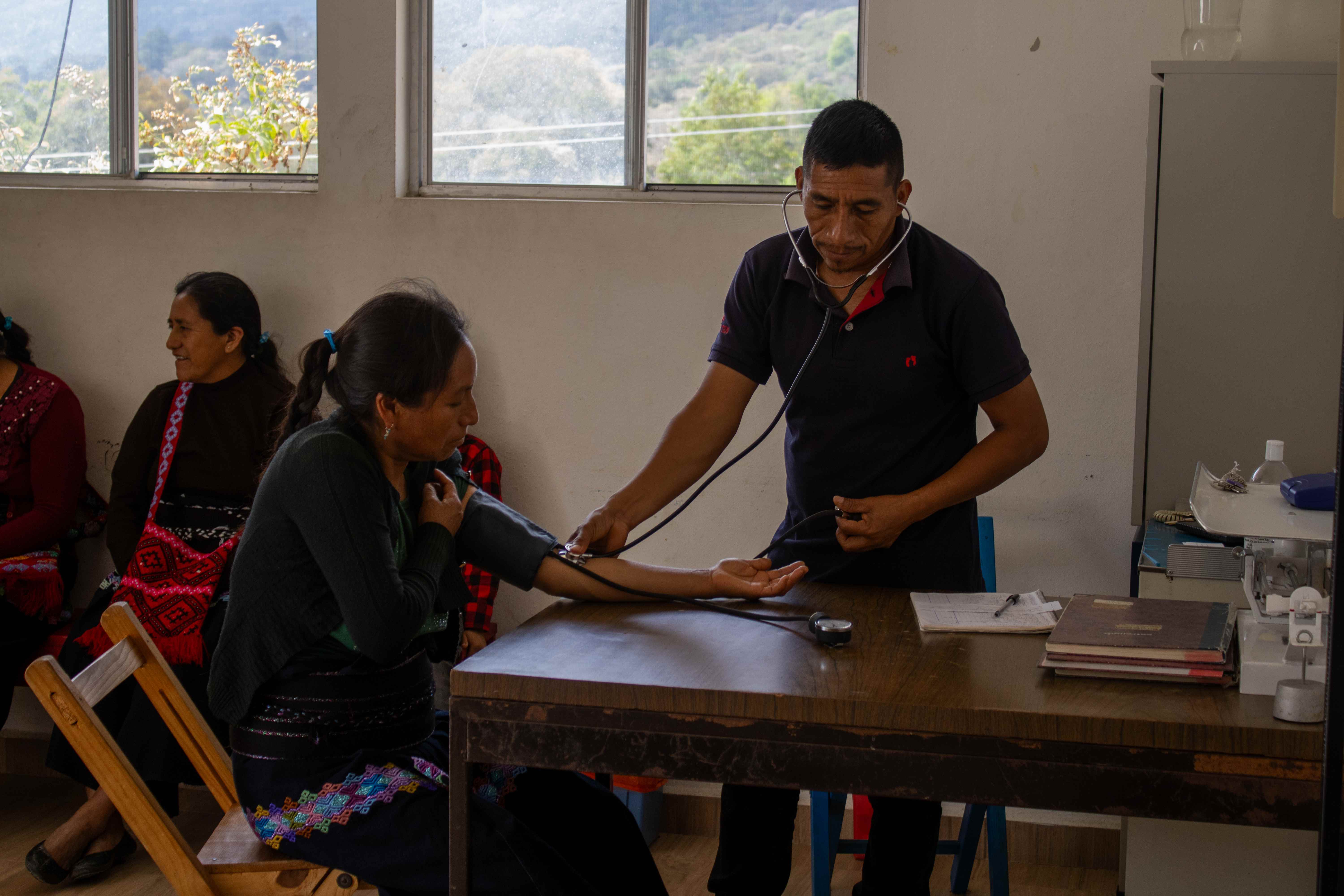 Personal médico tomando la presión arterial a una paciente en la clínica.